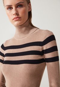 Beige Rollkragenpullover mit schwarzen horizontalen Streifen, gerippter Textur, taillierter Passform und hohem Kragen.