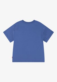 Camiseta de algodón azul, de mangas cortas, cuello redondo, ajuste relajado, diseño liso, con una pequeña etiqueta de logo en el costado.