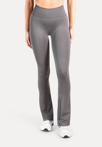 Grijze legging met een hoge taille, gemaakt van een glad, rekbaar stof met een strakke pasvorm, voorzien van een subtiele geribbelde tailleband en uitlopende pijpen.