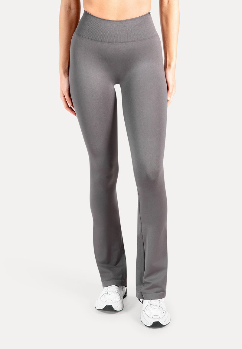 Grijze legging met een hoge taille, gemaakt van een glad, rekbaar stof met een strakke pasvorm, voorzien van een subtiele geribbelde tailleband en uitlopende pijpen.