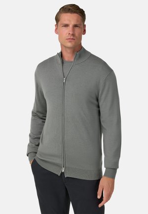 Maglione grigio con zip e colletto alto, polsini e orlo a coste; realizzato in materiale morbido, con una texture liscia e un design aderente.
