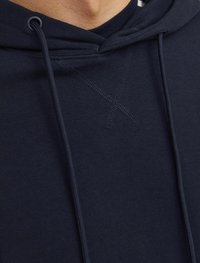 Navy Hoodie mit Kordelzug, weichem Stoff, strukturierter Naht und einer Kängurutasche. Nahaufnahme, die den Halsausschnitt und die Details hervorhebt.