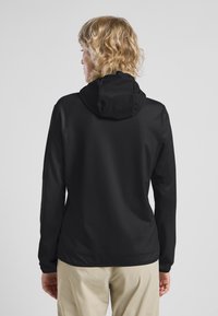 Giacca nera con cappuccio e maniche lunghe, realizzata in materiale morbido; presenta una vestibilità comoda e un design minimalista, senza motivi o accenti visibili.