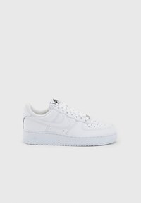 White low-top Nike Air Force 1 sneaker with laces, perforated toe box, and signature swoosh on a plain light background.
