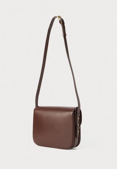 Sac en cuir brun à bandoulière avec un design plat, des bords arrondis, une sangle réglable et des accents en métal doré.