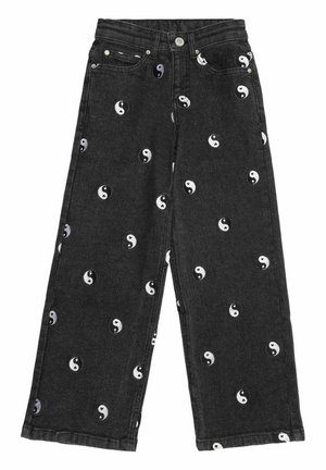 Jean noir à jambes larges avec des symboles yin-yang blancs et noirs dispersés, bouton frontal et design à cinq poches sur fond blanc.