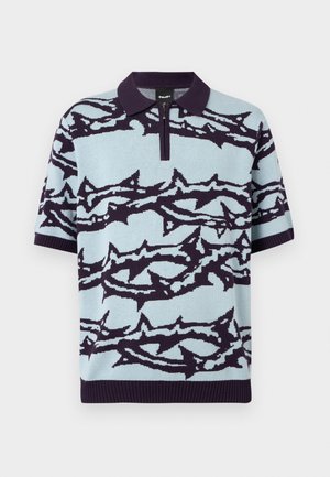 Polo bleu clair à manches courtes avec des rayures abstraites bleu marine foncé ressemblant à des épines et une fermeture éclair quart sous un col sombre.