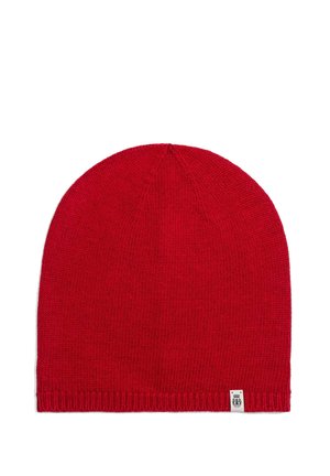 Rote gestrickte Beanie-Mütze mit kleinem weißem rechteckigem Etikett, das am unteren Rand auf einem weißen Hintergrund angenäht ist.