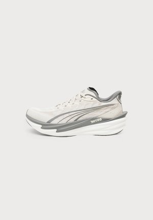 Ανοιχτό μπεζ και γκρι αθλητικό παπούτσι Puma με λευκή παχύ πυκνό σόλα και σήμανση "Nitro" στο πλάι.