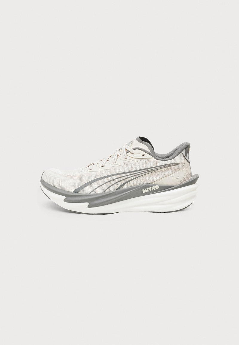 Chaussure de course Puma beige clair et grise avec semelle blanche épaisse et rembourrée et marquage "Nitro" sur le côté.