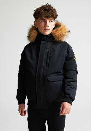 Chaqueta acolchada negra con capucha de pelo sintético en tono beige, presenta cierre frontal, dos bolsillos laterales y un pequeño bolsillo en el pecho.