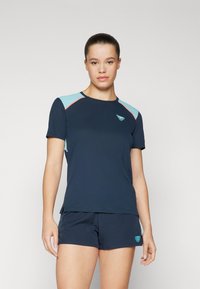 Mēteļa piedurkņu sportiskais tops tumši zilā krāsā ar gaiši ziliem plecu akcentiem, ar apaļu kakla izgriezumu un mazu logotipu uz krūtīm.