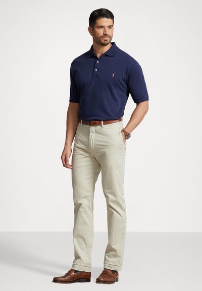 Jūras spēku polo krekls ar īsām piedurknēm, trīs pogu aizdare un izšuvums. Beidzot chinos bikses, brūns ādas josta un saderīgi apavi.