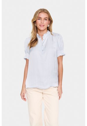 Light blue short-sleeve blouse with a stand-up collar, button placket, pleated details, and elasticized cuffs. Smooth, lightweight fabric.