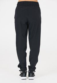 Schwarze, leichte Sporthosen mit elastischem Bund, tapered Beinen und gerafften Säumen. Mit Seitentaschen und glatter Textur.