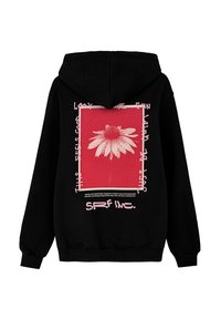 Czarna hoodie z czerwoną grafiką przedstawiającą białą stokrotkę i różowy tekst. Projekt zawiera prostokątną ramkę oraz zakrzywione akcenty tekstowe.