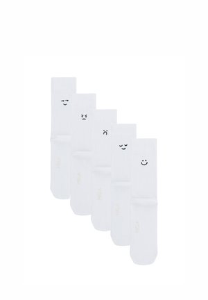 Fünf weiße Socken nebeneinander angeordnet, jede mit einem anderen schwarzen Emoji-Gesicht, das unterschiedliche Emotionen auf dem oberen Teil zeigt.