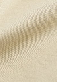 Beige stof met een fijne, gestructureerde weefsel; gladde uitstraling met subtiele lichtreflecties. Geschikt voor verschillende textieltoepassingen.