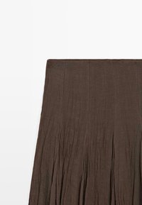 Mørkebrun plisseret nederdel med bred linning, lavet af let, struktureret stof, vist fladt på en hvid baggrund.