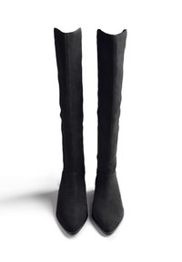 Botas de ante negras por encima de la rodilla con punta afilada y borde superior con ondas, con una textura suave y una silueta ajustada.