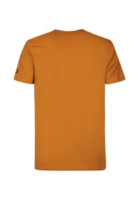 Camiseta de algodón naranja con cuello redondo, mangas cortas y un detalle de logo en el hombro izquierdo. Textura suave y ajuste relajado.