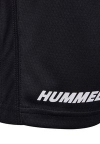 Svarta sportshorts i texturerat tyg med den vita "HUMMEL"-logotypen tryckt på nedre högra sidan. Har kontrastsömmar längs sömmarna.