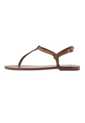 Sandalias planas marrones con un diseño minimalista, que cuentan con una tira en T, tachuelas metálicas y una correa ajustable en el tobillo. Suela suave y flexible.