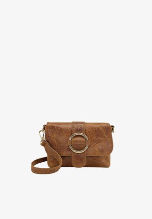 Sac bandoulière en cuir texturé marron avec une boucle circulaire dorée sur le rabat avant et une sangle réglable sur fond blanc.