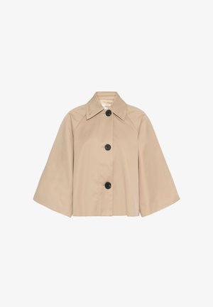 Jachetă bej cu mâneci largi și croială scurtă, cu nasturi negri mari și guler ascuțit, prezentată pe un fundal alb.