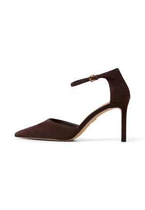 Dunkelbrauner Veloursleder-Pumps mit spitzer Spitze, Knöchelriemen und goldener Schnalle, schlanker Stiletto-Absatz, Seitenansicht auf weißem Hintergrund.