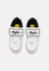 Vita sneakers med kviltad textur, grå accent, svart foder och en stor vit kardborreband med "Buffalo"-logotyp.