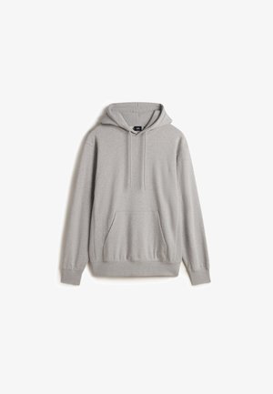 Sudadera con capucha gris hecha de una tela suave. Cuenta con un bolsillo frontal, puños y dobladillo acanalados, y cordones en la capucha.