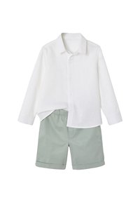 White linen shirt with long sleeves and a collar, paired with light green shorts featuring a cuffed hem. Casual summer outfit.