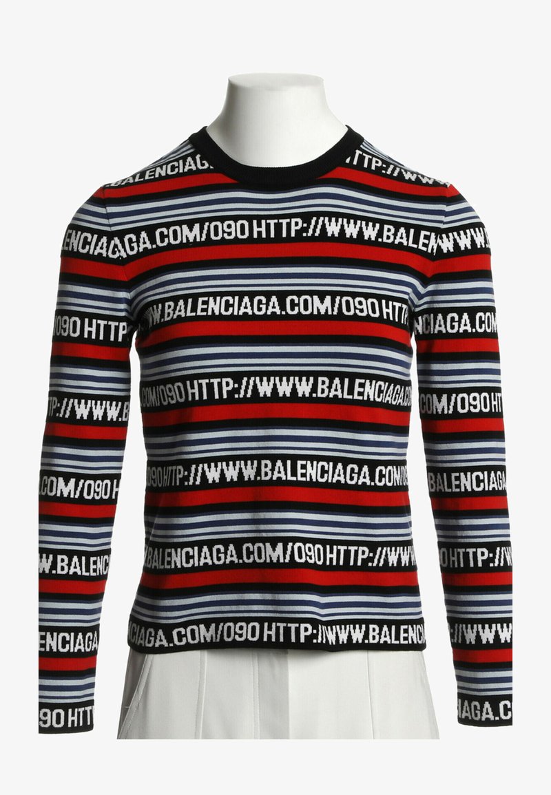 Pull à rayures manches longues avec bandes rouges, bleues et noires et texte blanc répété "HTTP://WWW.BALENCIAGA.COM/090" sur le tissu.
