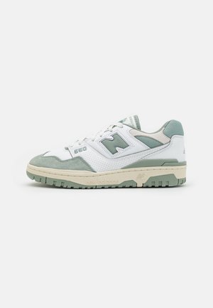 Weißer und salbeigrüner New Balance 550 Sneaker mit Wildleder- und perforierten Lederdetails, auf einem schlichten weißen Hintergrund dargestellt.