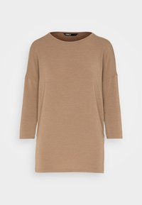 Lässig geschnittenes Oberteil mit Dreiviertelärmeln in Hellbraun, aus weichem Stoff gefertigt, mit rundem Halsausschnitt und einfachem Saum. Glatte Textur, minimalistisches Design.