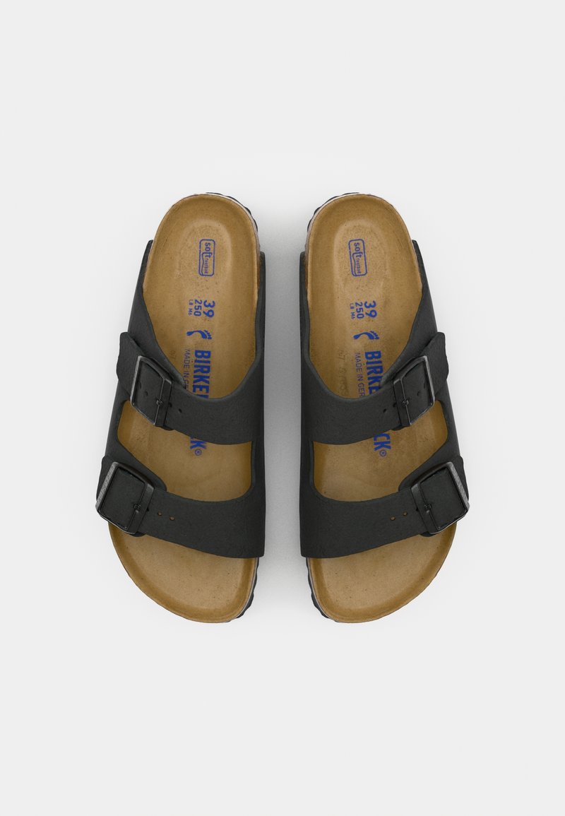 Schwarze Sandalen mit zwei Riemen und verstellbaren Schnallen, Korkfußbett und Gummisohle. Geprägtes Branding auf dem Fußbett sichtbar.