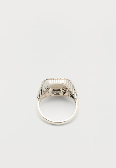 Ασημένιο ορθογώνιο δαχτυλίδι σήμα με κάθετες αυλακώσεις και μικρές ενσωματωμένες πέτρες στα πλάγια, εμφανιζόμενο από κάτω σε λευκό φόντο.