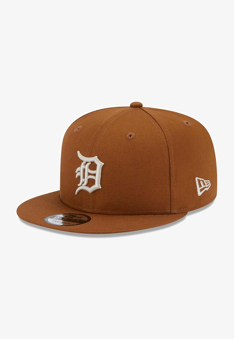 Brauner Stoffhut mit flacher Schirm. Vorne mit einem gestickten weißen "D"-Logo versehen und seitlich mit einem kleinen weißen Logo.