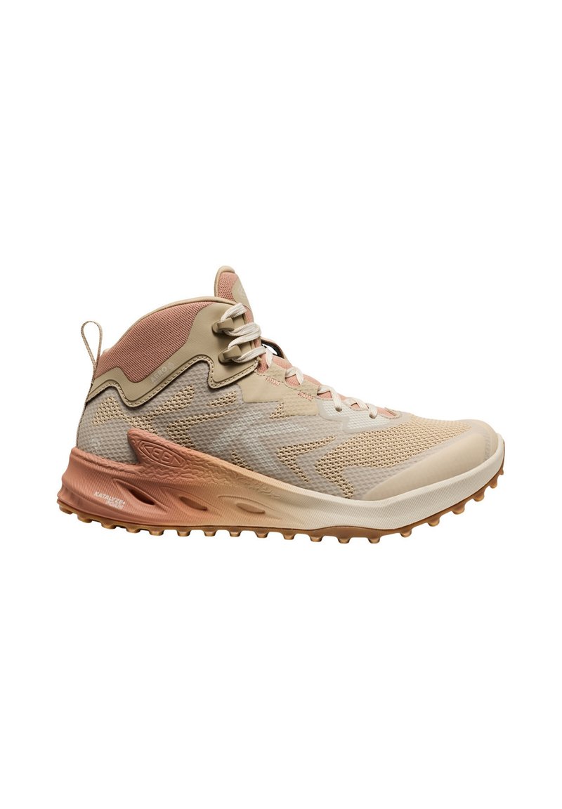 Scarpa da trekking beige con tomaia in mesh, suola in gomma e dettagli rosa. Presenta un tallone rinforzato e un colletto imbottito per il supporto.