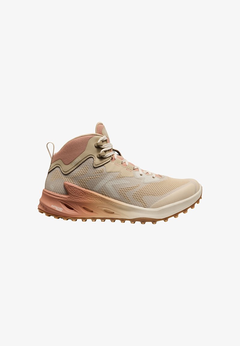 Scarpa da trekking beige con tomaia in mesh, suola in gomma e dettagli rosa. Presenta un tallone rinforzato e un colletto imbottito per il supporto.