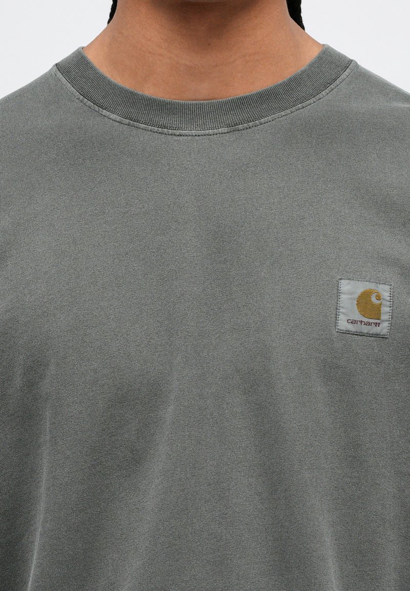 Grijze katoenen T-shirt met een ronde hals, voorzien van een klein Carhartt-logo in wit en geel, genaaid op de linker borst.