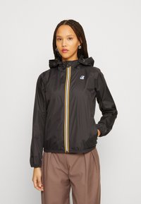 Zwarte lichtgewicht jas met een capuchon, voorzien van een rits aan de voorkant met gele en blauwe strepen, elastische manchetten en een klein logo op de borst.