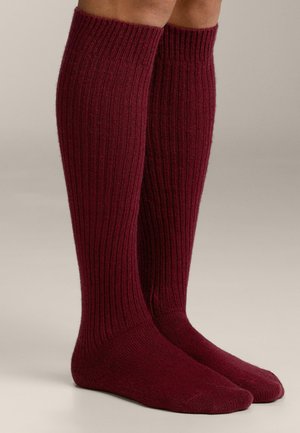 Bordó, térdig érő zokni bordázott mintával, puha anyagból, szoros felső résszel és sima orr-résszel.