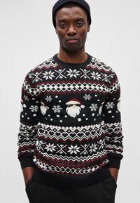 Suéter preto de malha com um design festivo de Pai Natal, flocos de neve e padrões geométricos em vermelho e branco. Gola e punhos canelados.