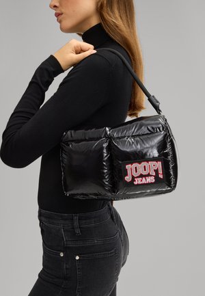 Črna puhasta torbica z sijočo teksturo, ki ima izstopajočo oznako z logotom "JOOP! JEANS" v rdeči in beli barvi, ter naramnico.