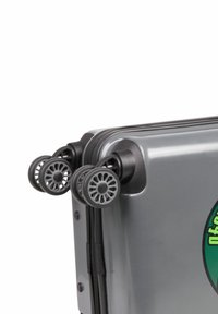 Grå hårdskalväska med en logotyp, med dragkedjestängning, två svarta plasthjul med fälgdesign, och kraftiga hörnanslutningar.