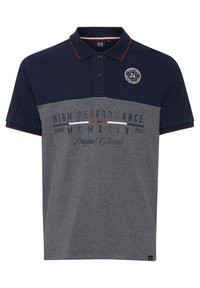 Navy ja harmaa polo paita lyhyillä hihoilla, kaula-aukolla ja nappilista. Sisältää tekstiprintin ja brodeeratun logon rinnassa.