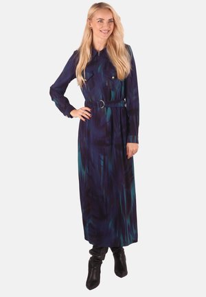 Langärmliges, kragenloses Kleid in Dunkelblau mit grünen und schwarzen abstrakten Mustern. Verfügt über eine taillierte Taille und knöpfbare Brusttaschen.