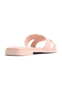 Sandales en plastique rose avec une texture lisse, dotées de découpes ouvertes et d'une semelle plate, présentant un design minimaliste.